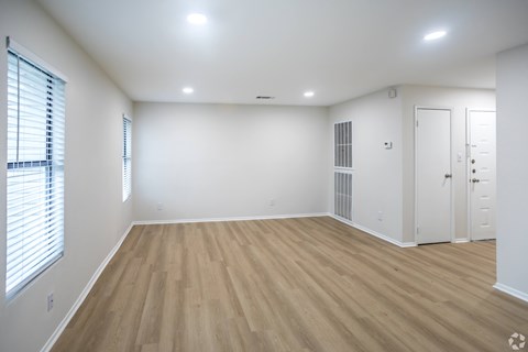 A room with wooden flooring and white walls.