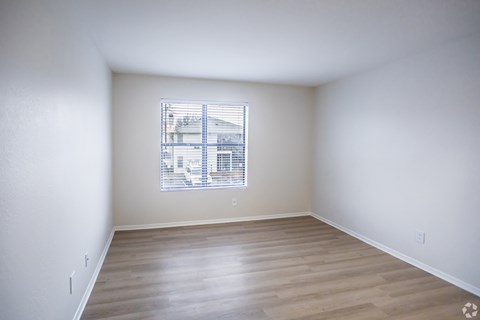 A room with a window and wooden flooring.