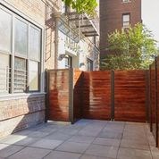 A brown fence is in front of a building.