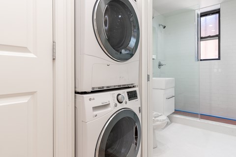 A white LG front load washing machine in a small laundry room.