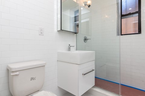 A white toilet and sink in a bathroom.
