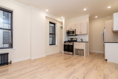 A kitchen with wooden floors and white walls.