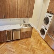 A kitchen with wooden cabinets and a washer and dryer.
