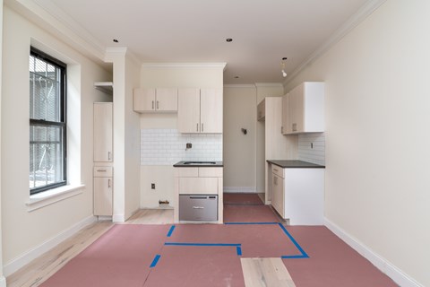 A kitchen with white cabinets and a black counter top.