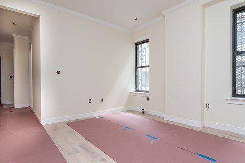 A room with white walls and a window with blinds.