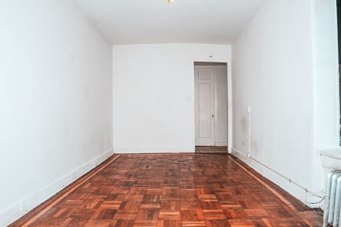 A room with a wooden floor and a white door.