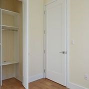 A white door is in a room with a white wall.