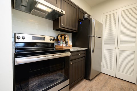 A kitchen with a black oven and a black fridge.