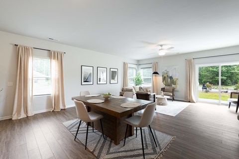 A dining room with a table set for four and a view of the backyard.