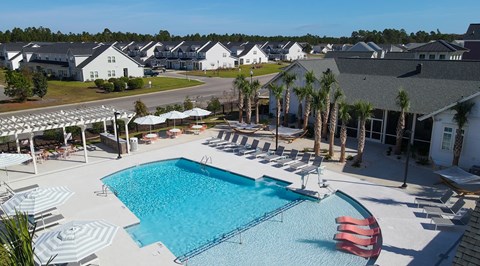 A large swimming pool surrounded by sun loungers and umbrellas.