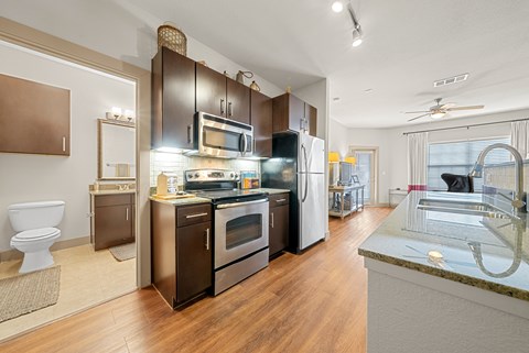 A modern kitchen with dark wood cabinets and stainless steel appliances.