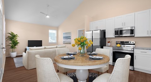 A modern kitchen and living room with a dining table set for two.