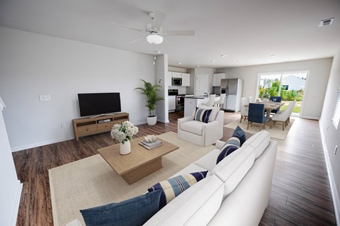 A living room with a white couch and a wooden coffee table.