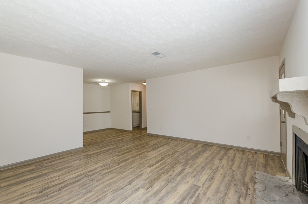 A room with wooden flooring and white walls.