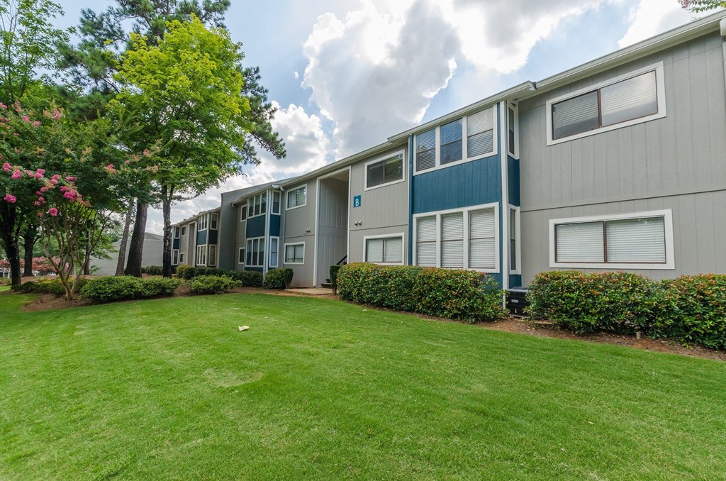 A row of townhouses with a green lawn in front.