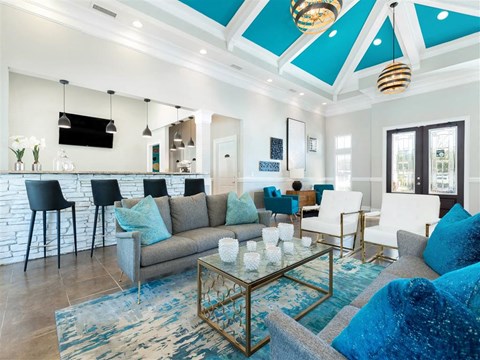 A living room with a grey couch and a glass coffee table.