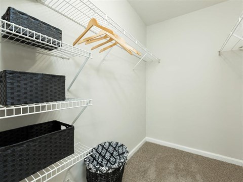 A white closet with a hanger and a basket.