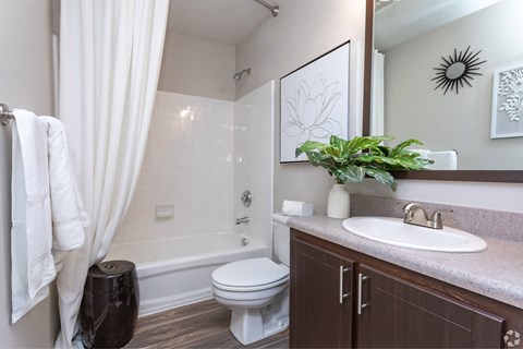 A bathroom with a white toilet, a white sink, and a white shower curtain.