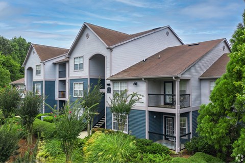 A large house with a balcony and a car parked in front.
