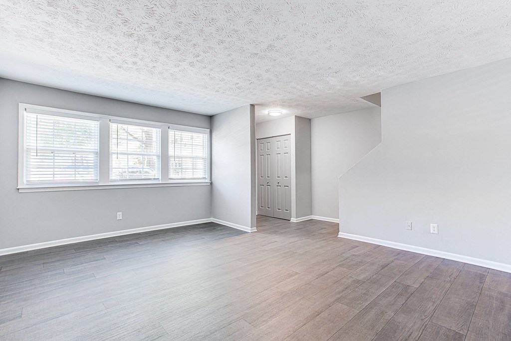 A room with a wooden floor and a white ceiling with a window.