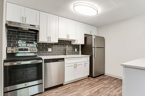 A kitchen with white cabinets and stainless steel appliances.