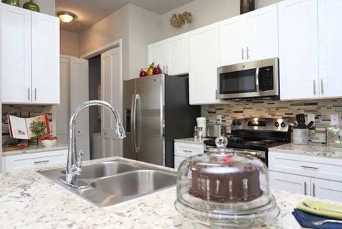 A kitchen with a stainless steel sink and refrigerator.