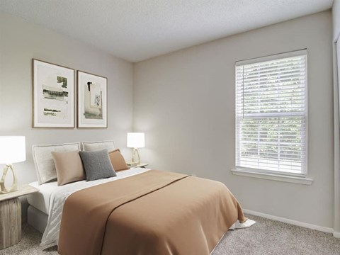 A bedroom with a bed, two lamps, and two pictures on the wall.