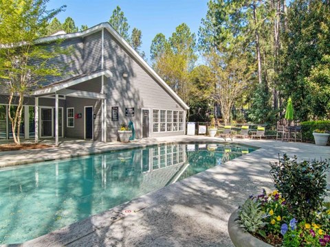 A house with a pool in front of it.