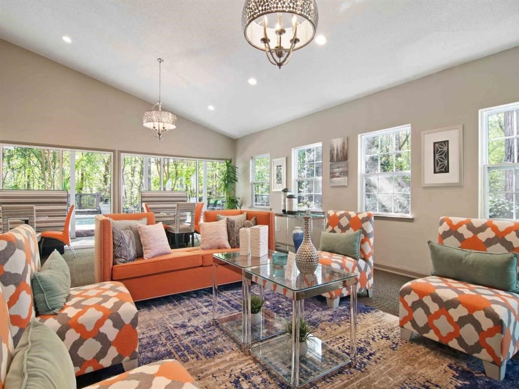 A living room with orange and white furniture and a chandelier.