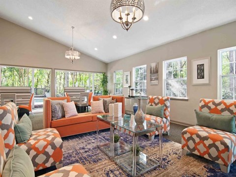 A living room with orange and white furniture and a chandelier.