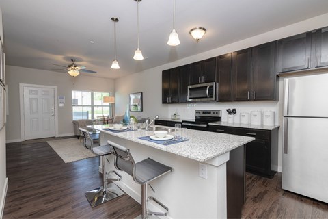 A kitchen with a white counter top and black cabinets.