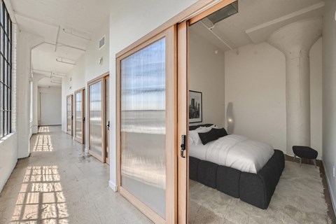 A bedroom with a bed, a window, and a door.