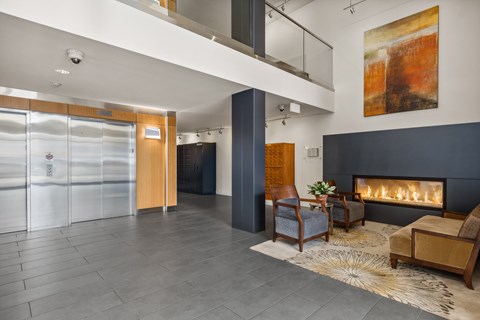 A modern living room with a fireplace and a painting on the wall.