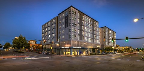 A large building with a lot of windows is lit up at night.