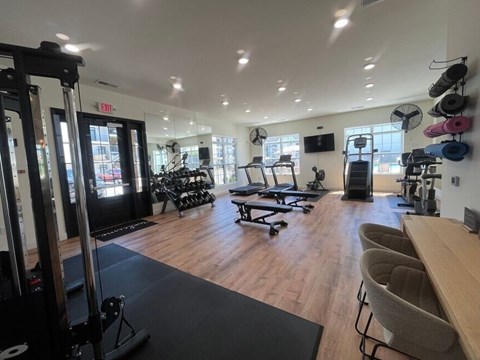 A gym with a variety of equipment including weights, machines, and a bench.