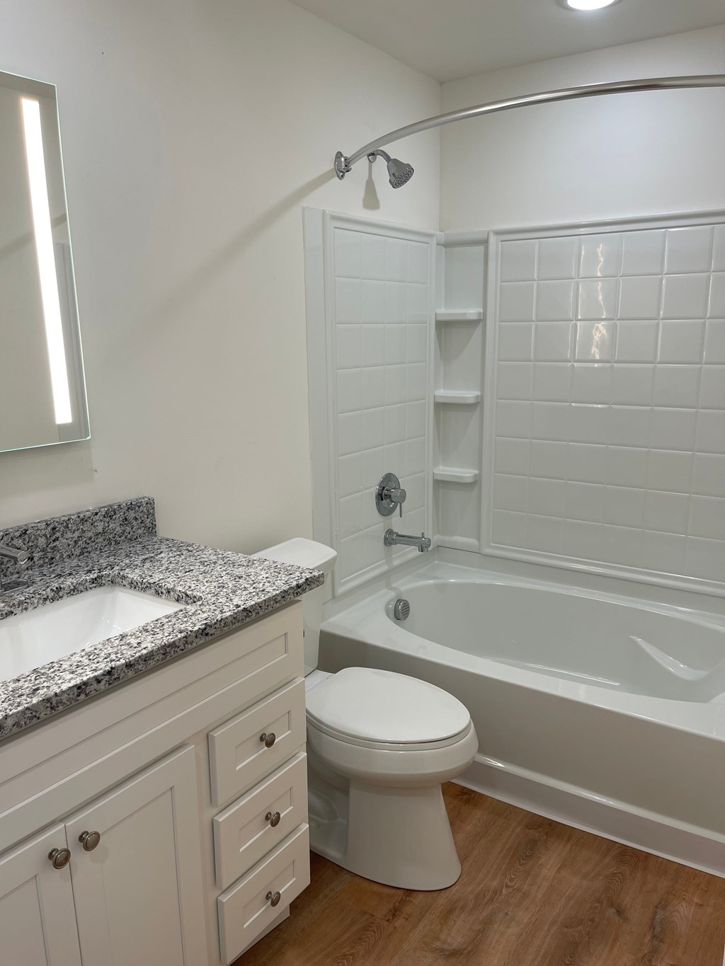 A white bathroom with a toilet, sink, and bathtub.