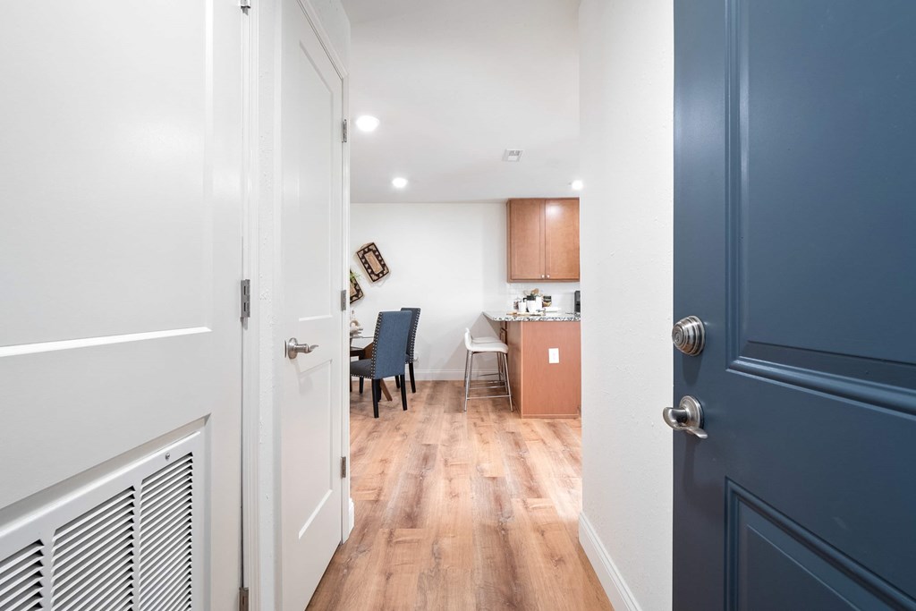 A hallway with a blue door and a white door.