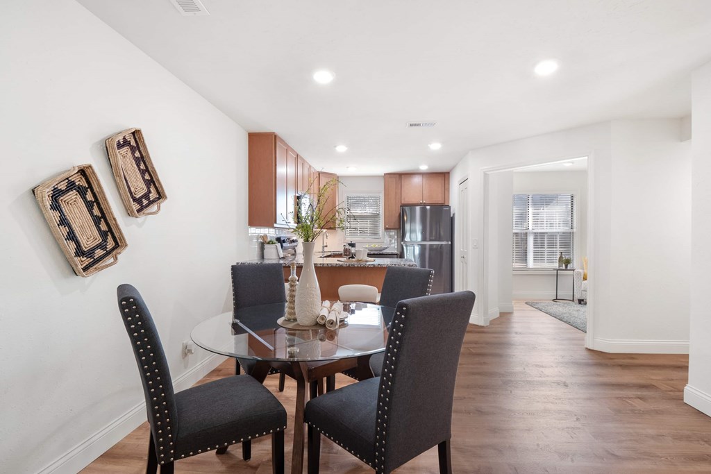 A dining room with a table and chairs.