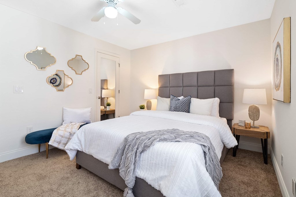A bedroom with a large bed and a ceiling fan.
