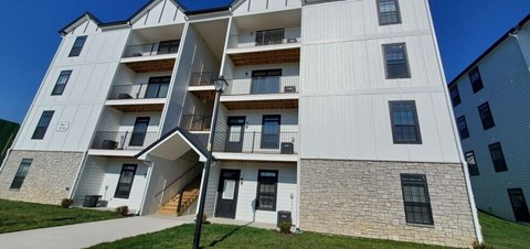 A white apartment building with balconies and doors.