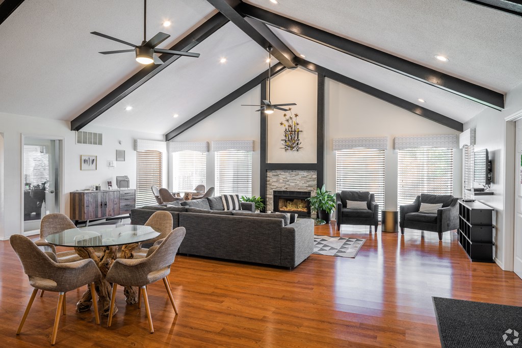 A modern living room with a glass table and a fireplace.
