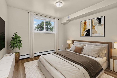 A well-lit bedroom with a large bed and a potted plant.