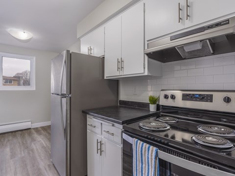 A kitchen with a black stove top oven and a black counter top.