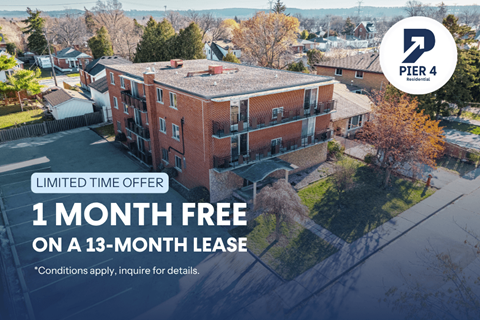 An aerial view of a brick apartment building with a sign offering a free month on a 13-month lease.