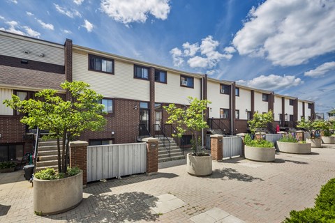 A sunny day at a residential area with apartment buildings and potted plants.