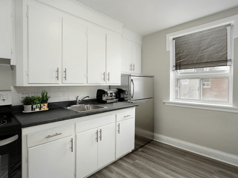 A kitchen with white cabinets and a black stove top.