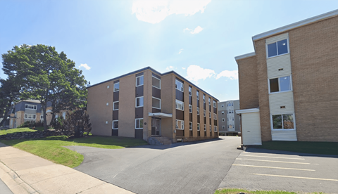 A sunny day at a residential area with apartment buildings and a parking lot.