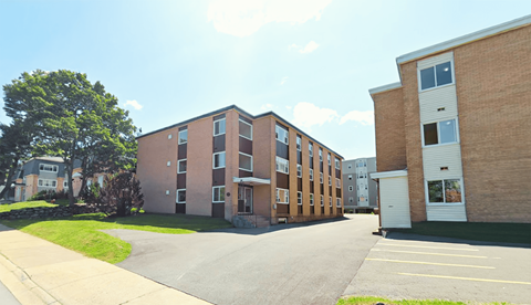 A large brick building with a parking lot in front.