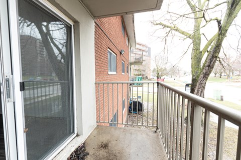 A balcony with a metal railing and a glass door.
