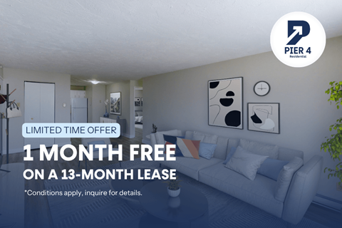 A living room with a couch and a poster on the wall advertising a free month on a 13-month lease.